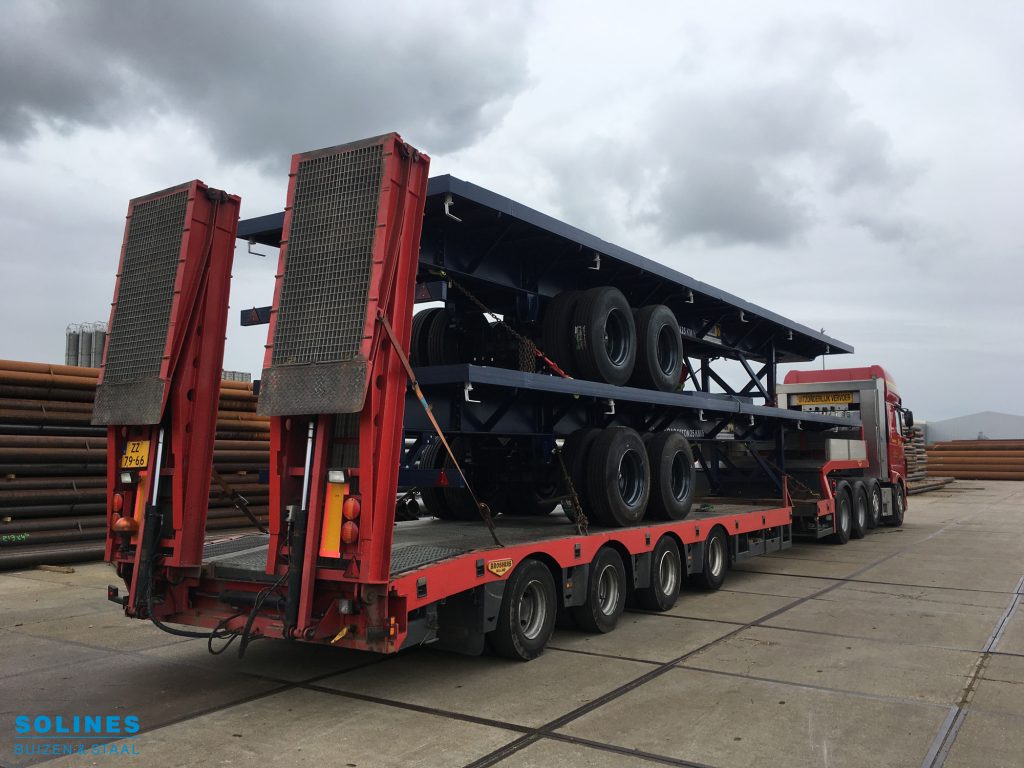 Houcon Flatbed trailers komen aan op een semi dieplader bij Solines B.V.